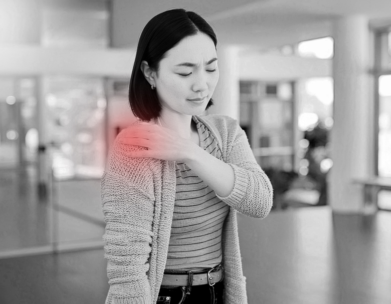 病院で異常なしと言われた後も肩に違和感があり、ロビーで肩を軽く押さえている女性の様子